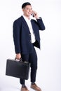 Asian 20s handsome young business man wearing formal suit, talking on mobile phone for communication working with confidence and Royalty Free Stock Photo