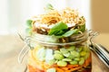 Asian salad in a jar with ramen noodles, red pepper, snow pea pods, carrots, edamame, shiitake mushrooms, salad greens, fried chow