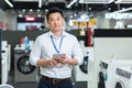 Asian salesman manager in home appliance store holding tablet and looking at camera smiling, successful store manager Royalty Free Stock Photo