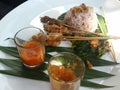 Asian Satay and rice presented beautifully with condiments on a banana leaf