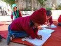Asian school kids reading during winter season in open area class in India January 2020 Royalty Free Stock Photo