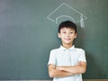 Asian schoolboy standing under a chalk-drawn doctoral cap