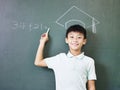 Asian schoolboy standing under a chalk-drawn doctoral hat