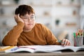 Asian schooler chubby boy dreaming about something while doing homework Royalty Free Stock Photo