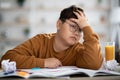 Asian schooler dreaming about something while doing homework Royalty Free Stock Photo