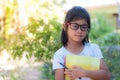 Asian schoolgirl holding books and pencils