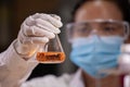 Scientist is holding a test tube with orange liquid chemical for analysis and research chemical test in a laboratory Royalty Free Stock Photo