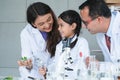 Asian scientist kid student and Indian teacher have fun with plant at biology class in school laboratory, do an experiment, using Royalty Free Stock Photo