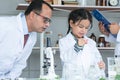 Asian scientist kid student and Indian teacher with plant at biology class in school laboratory, do an experiment, learning, Royalty Free Stock Photo