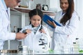 Asian scientist kid student and Indian teacher with plant at biology class in school laboratory, learning, teaching, holding Royalty Free Stock Photo