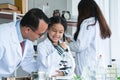 Asian scientist kid student and Indian teacher with plant at biology class in school laboratory, smiling, teaching child girl to Royalty Free Stock Photo