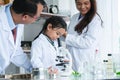 Asian scientist kid student and Indian teacher with plant at biology class in school laboratory, smiling, teaching child girl to Royalty Free Stock Photo