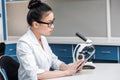 Asian scientist in lab coat with microscope and digital tablet Royalty Free Stock Photo