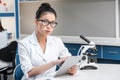 Asian scientist in lab coat with microscope and digital tablet Royalty Free Stock Photo