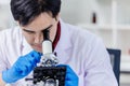 Asian scientist researcher looking at microscope working in medical lab Royalty Free Stock Photo