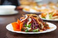 Asian sea food in Vietnamese restaurant.Eel salad with red cabbafe and fresh vegetables served on white plate in cafe.Delicious