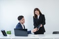 Asian secretary woman is holding and showing company performance report on tablet to her young handsome boss at office Royalty Free Stock Photo