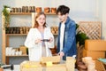 Asian seller man and Caucasian entrepreneur woman record video before unbox wooden vase and coaster product for claim if they have