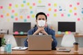 Asian senior business man in casual wearing mask working with laptop in modern office or co-working space Due Covid-19 Flu Pandemi