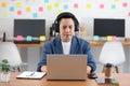 Asian Senior business man wearing earphone meeting with business team via video conference call at Home or Co-Working Space Royalty Free Stock Photo