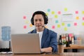 Asian Senior business man wearing earphone meeting with business team via video conference call at Home Royalty Free Stock Photo