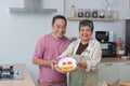 Asian senior couple cooking together in kitchen, Making eggs for breakfast Royalty Free Stock Photo