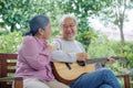 Asian senior couple elderly man playing guitar while his wife singing together Royalty Free Stock Photo