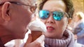 Asian senior couple enjoying ice cream during vacation holiday t