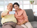 Asian senior couple having good time together,sitting in living room , talking selfie photo or video chatting looking at  smart Royalty Free Stock Photo