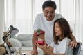 Asian senior couple having goodtime together with gift giving for happy anniversary