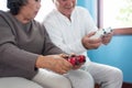 Asian Senior Couple holding joysticks and playing video games to