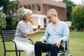 Asian Senior couple sitting in wheelchairs taking care of each other.in romantic time They laughing and smiling while sitting Royalty Free Stock Photo