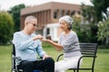 Asian Senior couple sitting in wheelchairs taking care of each other.in romantic time They laughing and smiling while sitting Royalty Free Stock Photo