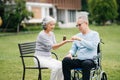 Asian Senior couple sitting in wheelchairs taking care of each other.in romantic time They laughing and smiling while sitting Royalty Free Stock Photo