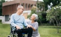 Asian Senior couple sitting in wheelchairs taking care of each other.in romantic time They laughing and smiling while sitting Royalty Free Stock Photo