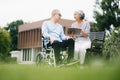 Asian Senior couple sitting in wheelchairs taking care of each other.in romantic time They laughing and smiling while sitting Royalty Free Stock Photo