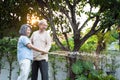 Asian Senior couple spending time outdoor gardening together at home. Attractive old grandparents use hose to watering Plants in Royalty Free Stock Photo