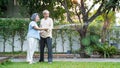 Asian senior couple spending time outdoor gardening together at home. Attractive older grandparent use hose to watering Plants in