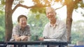 Asian senior couple start morning coffee in park, optimistic con Royalty Free Stock Photo