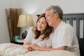 Asian senior couple talking on bed at home. Asian Senior Chinese grandparents, husband and wife happy relax together after wake up Royalty Free Stock Photo