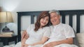 Asian senior couple talking on bed at home. Asian Senior Chinese grandparents, husband and wife happy relax together after wake up Royalty Free Stock Photo