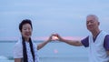 Asian senior couple together at sunrise beach. New year, new chapter concept Royalty Free Stock Photo