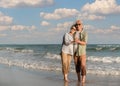 Asian senior couple tourist is hand in hands, embrace and dancing on tropical sea beach in summer vacation