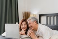 Asian senior couple using laptop at home. Asian Senior Chinese grandparents, husband and wife happy after wake up, watching movie Royalty Free Stock Photo