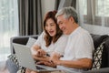 Asian senior couple using laptop at home. Asian Senior Chinese grandparents, surf the Internet to check social media while lying Royalty Free Stock Photo