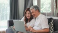 Asian senior couple using laptop at home. Asian Senior Chinese grandparents, surf the Internet to check social media while lying Royalty Free Stock Photo