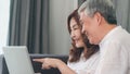 Asian senior couple video call at home. Asian Senior Chinese grandparents, using laptop video call talking with family grandchild Royalty Free Stock Photo