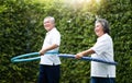 Asian Senior Couple exercising with hula hoops Royalty Free Stock Photo
