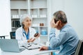 Asian Senior Doctor and patient discussing something while sitting at the table . Medicine and health care concept Royalty Free Stock Photo