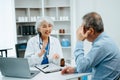 Asian Senior Doctor and patient discussing something while sitting at the table . Medicine and health care concept Royalty Free Stock Photo